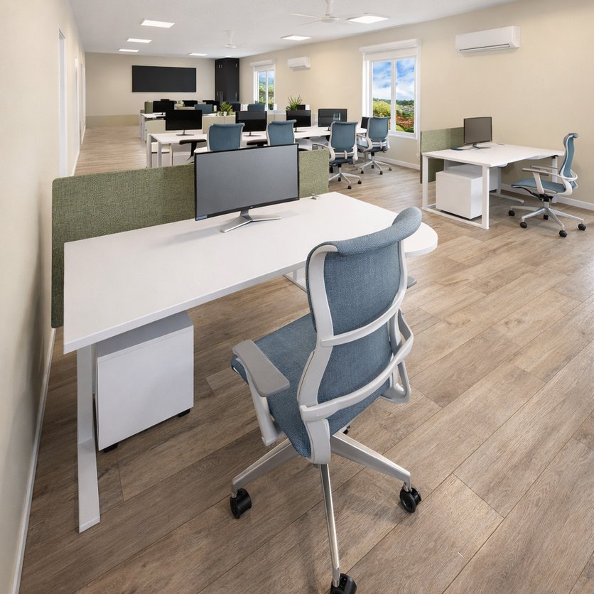 Rows of white desks with green fabric privacy screens and monitors in a light office, blue mesh office chairs, one in the foreground